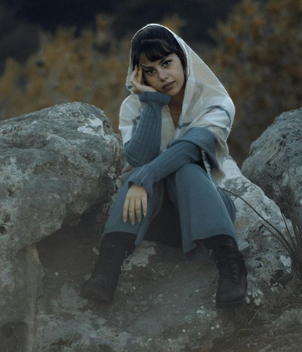 Serene woman in a meditative pose surrounded by calm, cool colors.